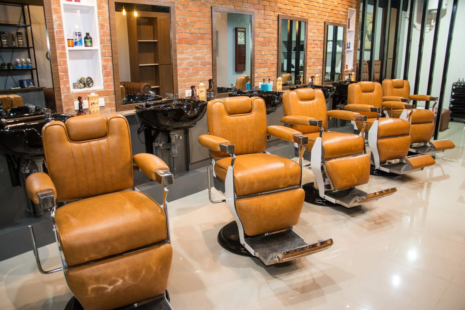 Una fila di poltrone da barbiere in pelle in una barberia