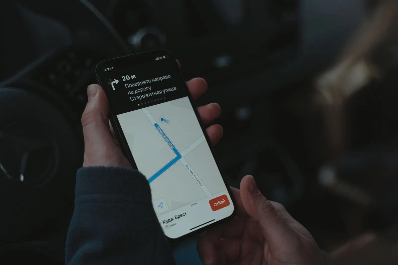 Una mano tiene un telefono con una mappa e un percorso sullo schermo