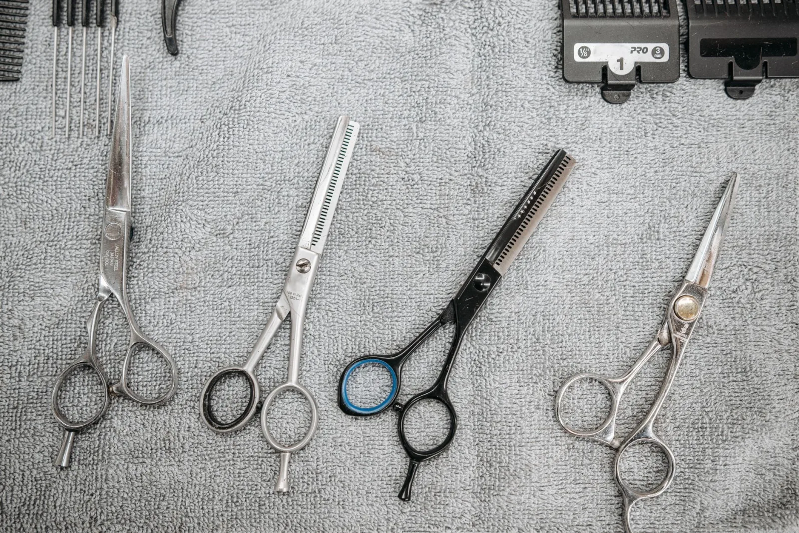 Des ciseaux de coiffure posés sur une serviette grise